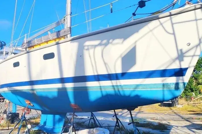 Hunter 430 sailboat from 1997 on dry dock, featuring a blue and white hull.