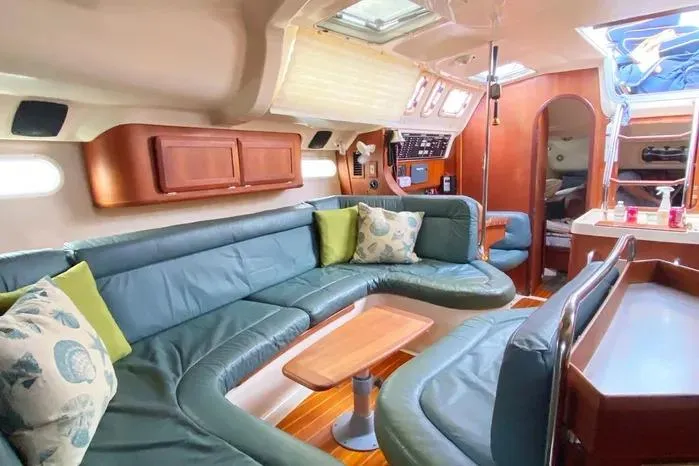 Interior of a 1997 Hunter 430 yacht with green seating and wooden accents.