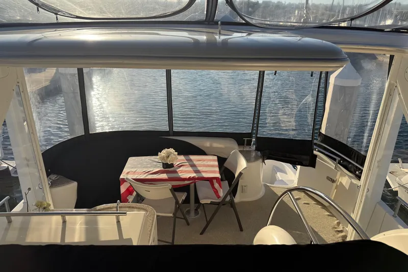 Y-knot Yacht Photos Pics 2007 Meridian 459 Motoryacht interior with table, chairs, and water view.