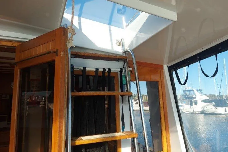 Kallisto Yacht Photos Pics 1982 Kadey-Krogen Krogen 42 Trawler interior with wooden ladder and marina view.