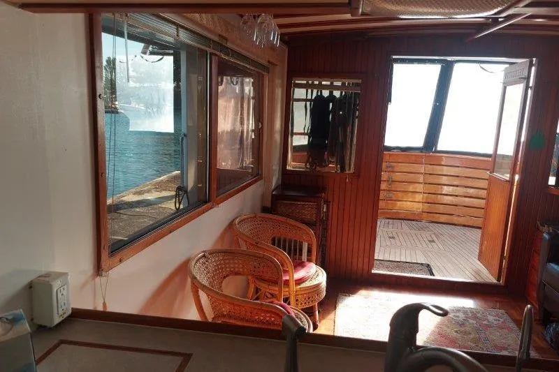 Kallisto Yacht Photos Pics Interior of 1982 Kadey-Krogen Krogen 42 Trawler with wicker chairs and wooden paneling.