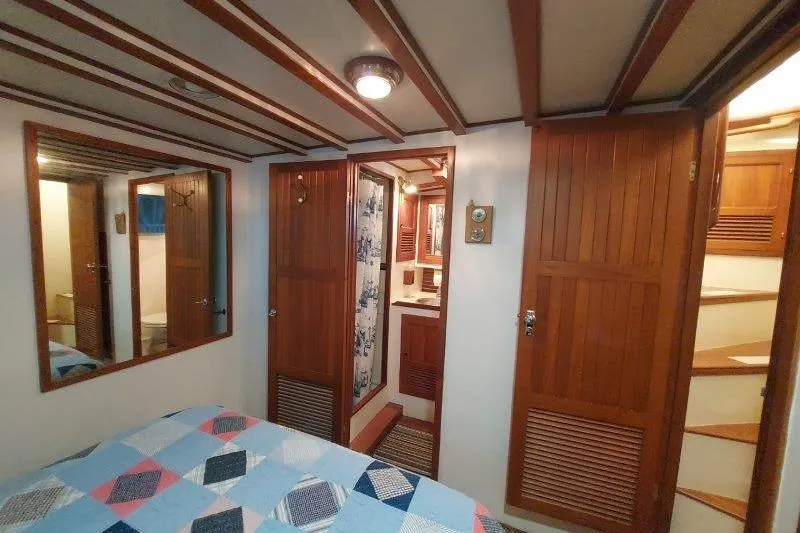 Kallisto Yacht Photos Pics Interior of 1982 Kadey-Krogen Krogen 42 Trawler with wooden paneling and quilted bedspread.