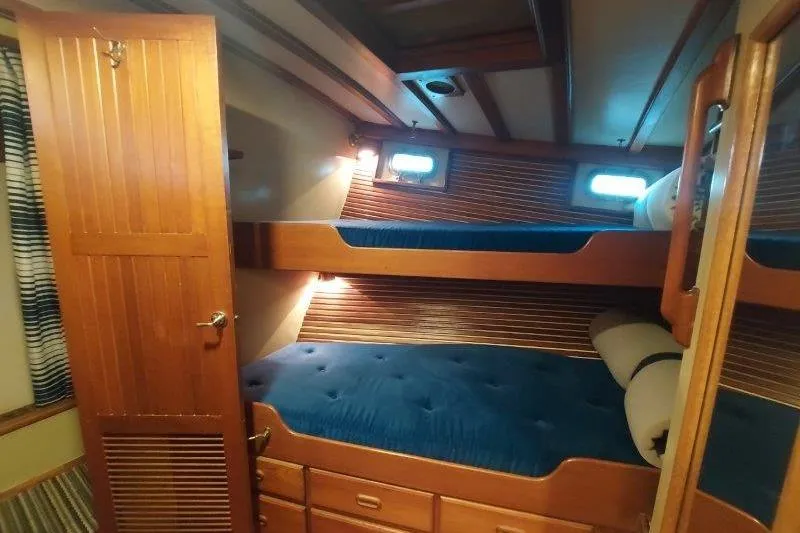 Kallisto Yacht Photos Pics 1982 Kadey-Krogen Krogen 42 Trawler cabin with wooden bunk beds and blue cushions.