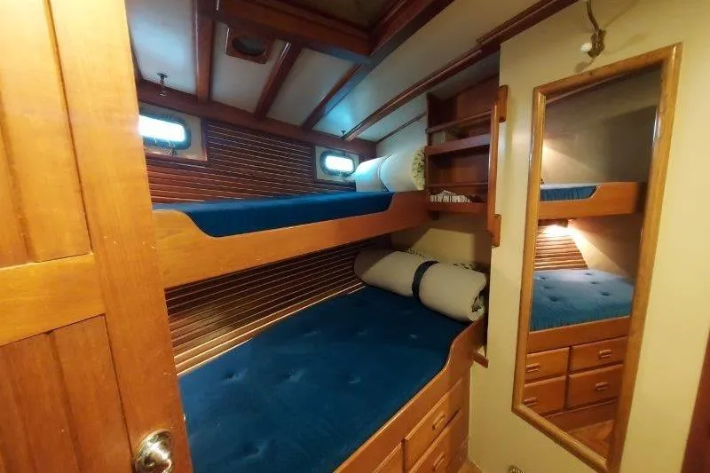 Kallisto Yacht Photos Pics 1982 Kadey-Krogen Krogen 42 Trawler cabin with wooden bunk beds and blue cushions.