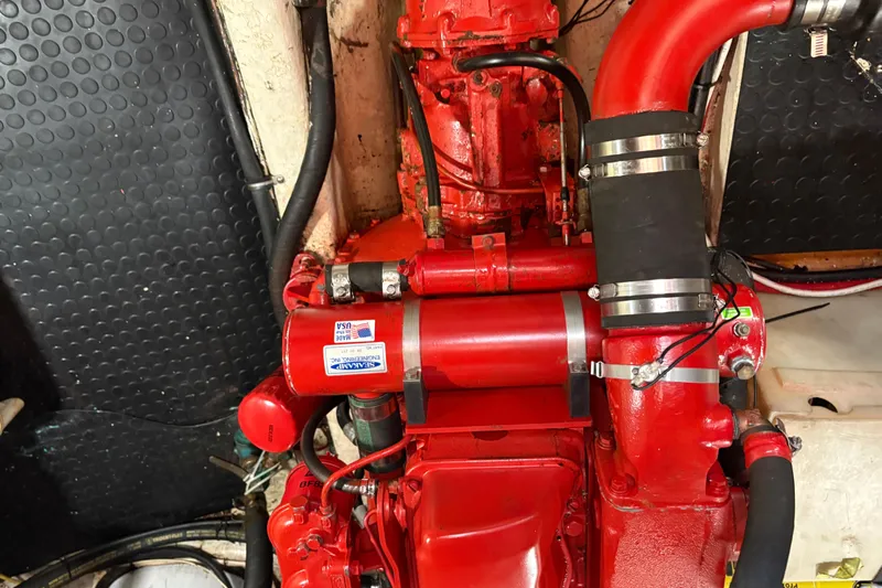 Kallisto Yacht Photos Pics Engine room of a 1982 Kadey-Krogen Pilothouse with red machinery and hoses.