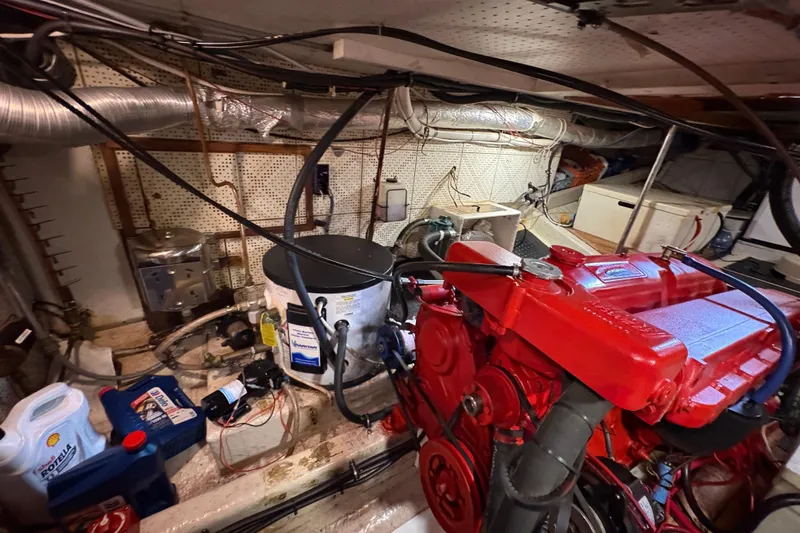 Kallisto Yacht Photos Pics Engine room of a 1982 Kadey-Krogen Pilothouse with red machinery and maintenance supplies.