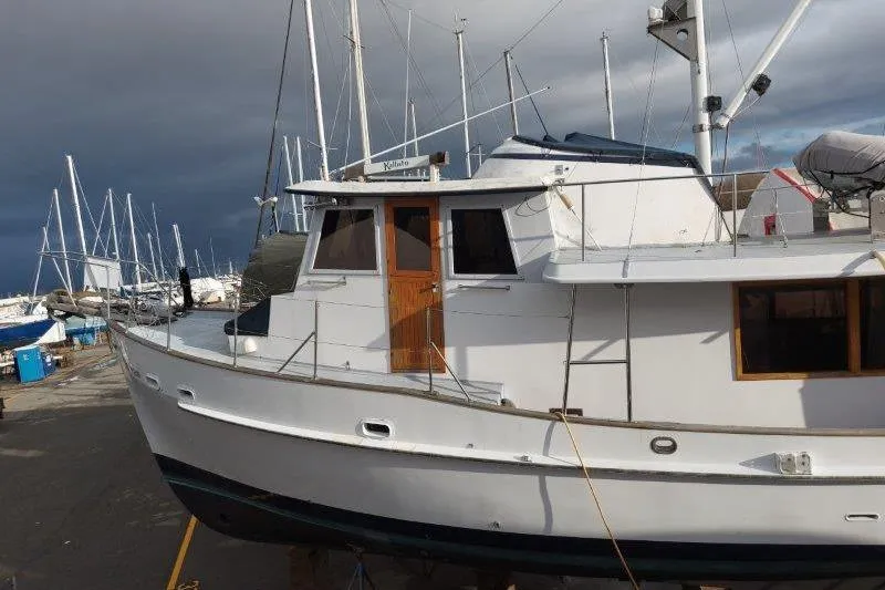 Kallisto Yacht Photos Pics 1982 Kadey-Krogen Pilothouse boat docked, surrounded by other sailboats under a cloudy sky.