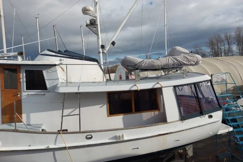 Kallisto Yacht Photos Pics 1982 Kadey-Krogen Pilothouse boat docked, featuring a covered dinghy on deck.