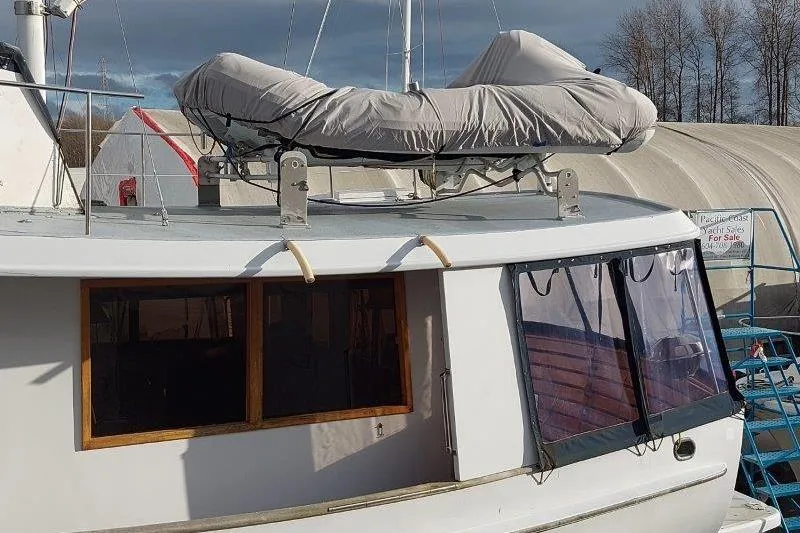 Kallisto Yacht Photos Pics 1982 Kadey-Krogen Pilothouse boat with covered dinghy on deck, docked near tents.