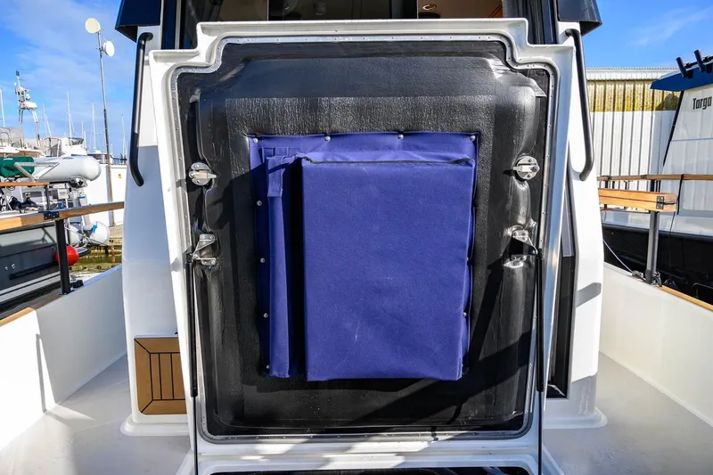  Yacht Photos Pics 2023 Targa 27.2 boat with blue canvas cover on rear deck, docked at marina.