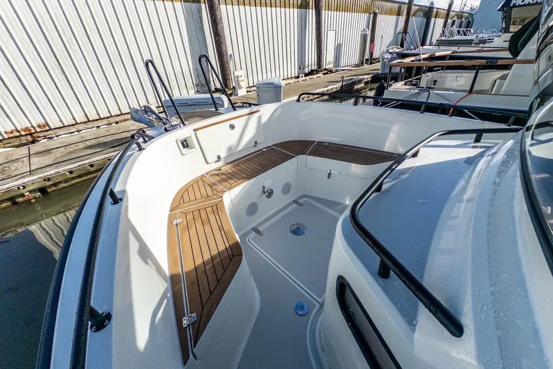  Yacht Photos Pics 2023 Targa 27.2 boat deck with wooden seating, docked at marina.