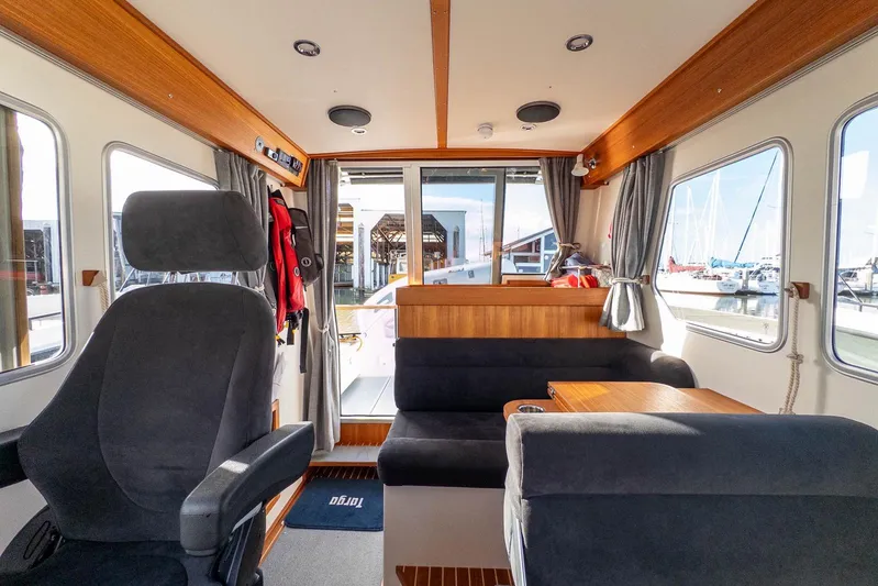  Yacht Photos Pics Interior of 2023 Targa 27.2 boat, featuring seating and windows with marina view.