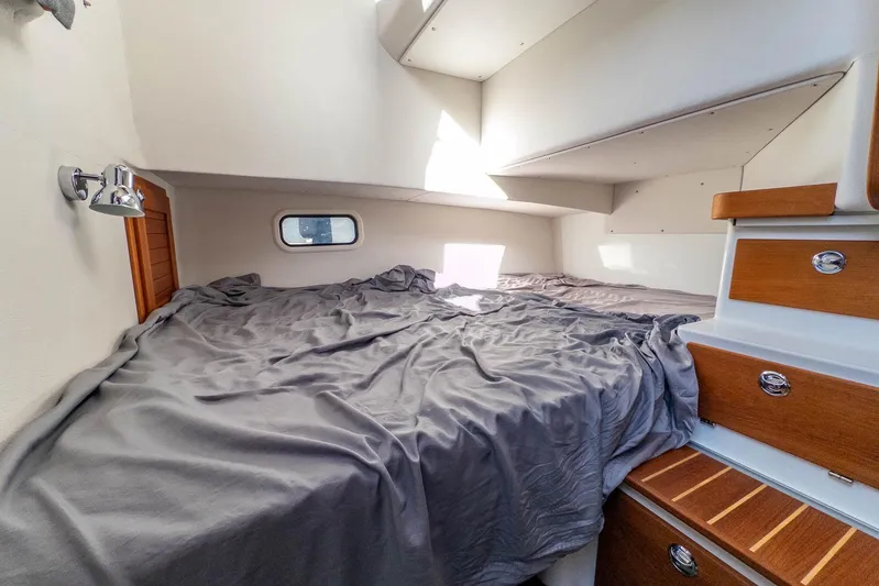 Yacht Photos Pics 2023 Targa 27.2 cabin interior with bed, wooden drawers, and window.