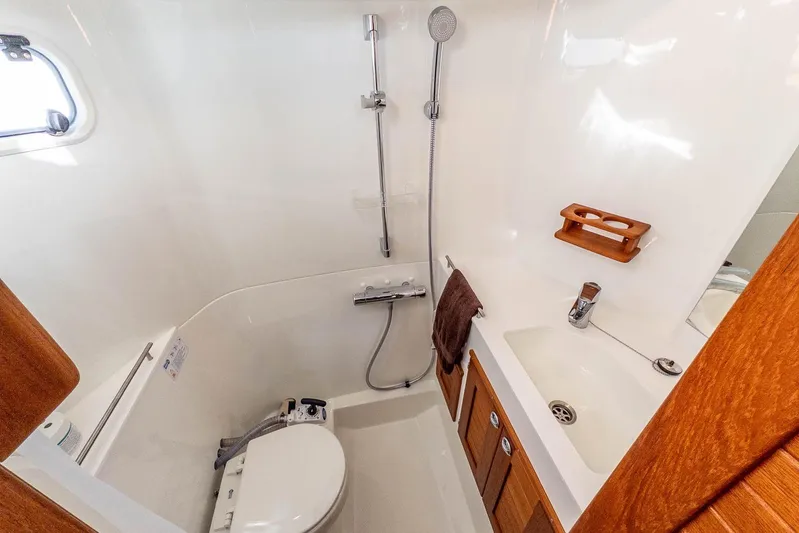  Yacht Photos Pics 2023 Targa 27.2 boat bathroom with shower, sink, and wooden accents.