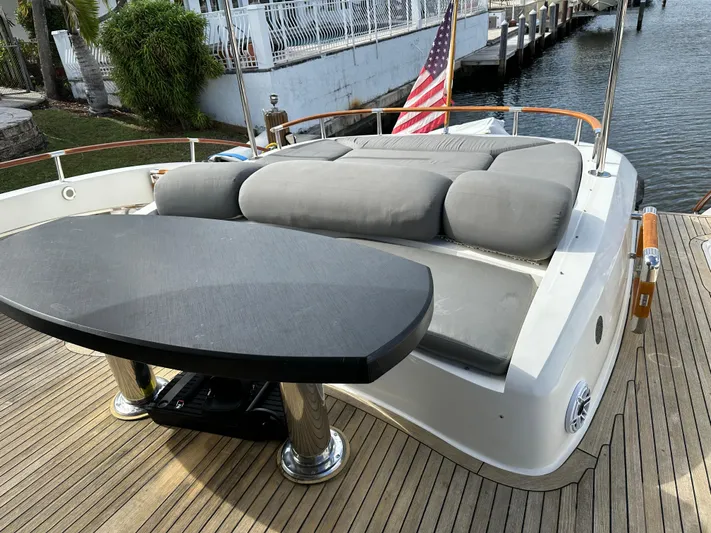 Volk Yacht Photos Pics Luxury 2009 Lazzara LSX 75 yacht deck with seating and table, docked by water.