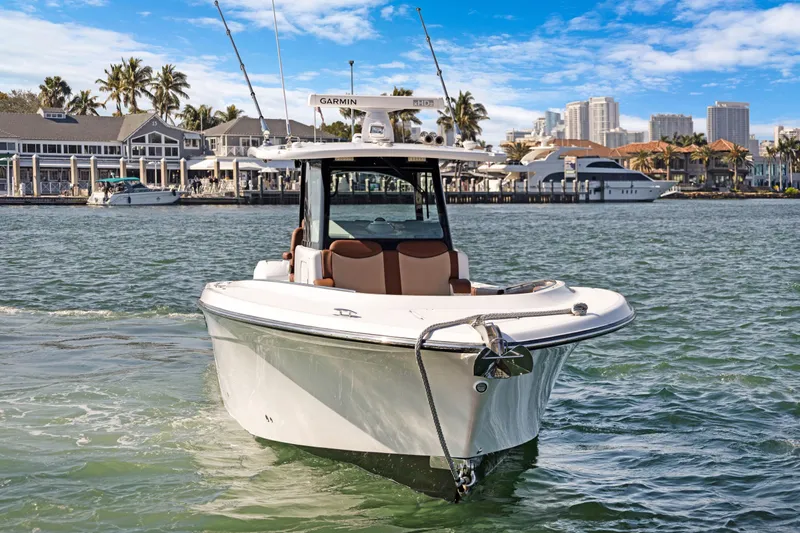  Yacht Photos Pics 2023 HCB Speciale boat cruising near a marina with city skyline backdrop.