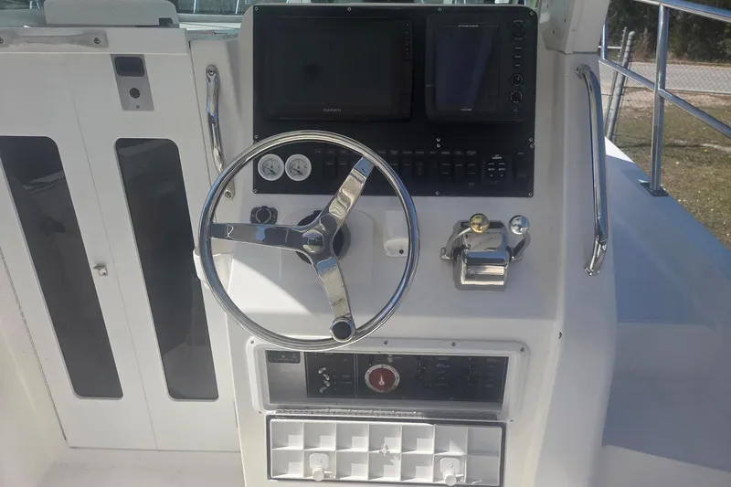 Smooth Operator Yacht Photos Pics 2008 True World Marine TE2810 boat helm with steering wheel and navigation controls.