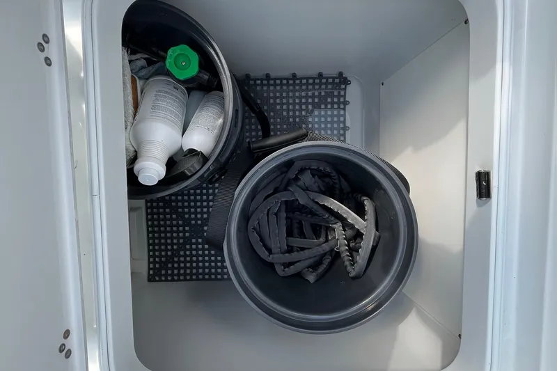 Lunasea Yacht Photos Pics Storage compartment on 2023 Yellowfin 32 Offshore boat with cleaning supplies and hoses.