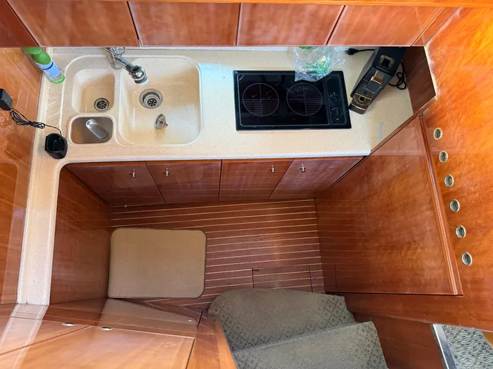 Miss Mazee Yacht Photos Pics Kitchen area of a 1996 Azimut 54 yacht with wooden cabinetry and modern appliances.
