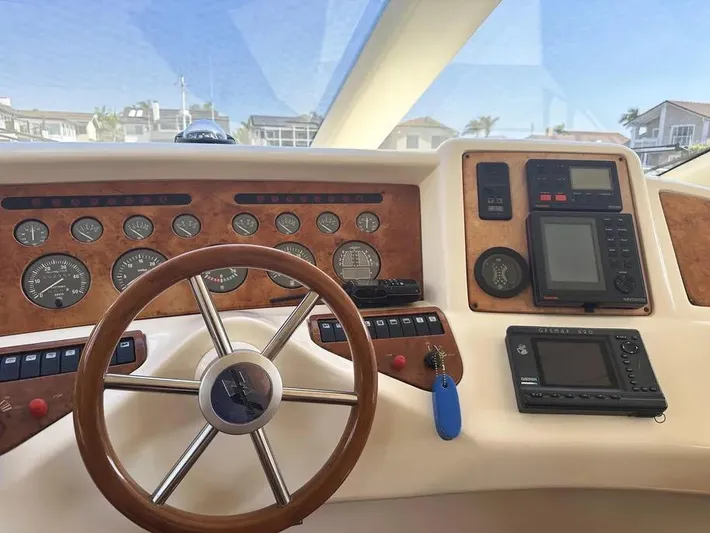 Miss Mazee Yacht Photos Pics 1996 Azimut 54 yacht dashboard with wooden steering wheel and navigation instruments.