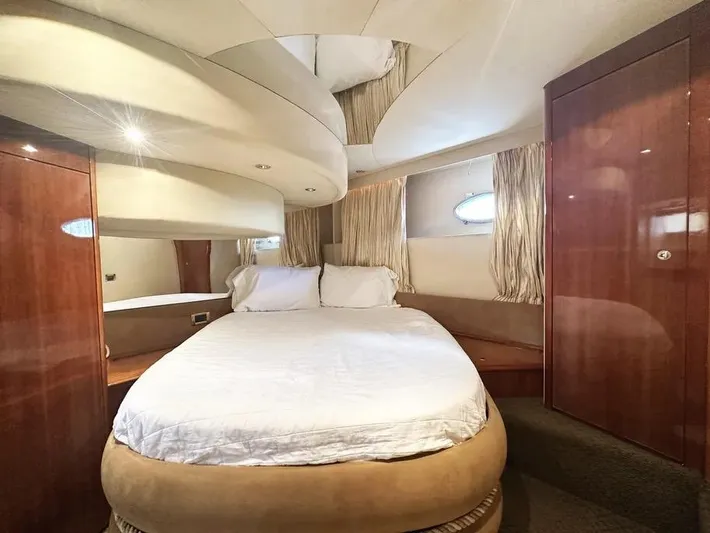 Miss Mazee Yacht Photos Pics Luxurious bedroom interior of a 1996 Azimut 54 yacht with elegant wood finishes.