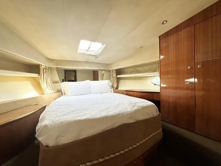 Miss Mazee Yacht Photos Pics Luxurious bedroom interior of a 1996 Azimut 54 yacht with elegant wood finishes.