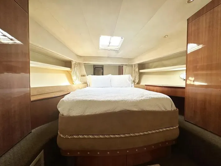 Miss Mazee Yacht Photos Pics Luxurious bedroom interior of a 1996 Azimut 54 yacht with elegant wood finishes.