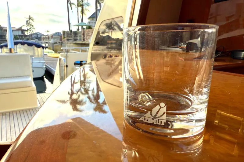 Miss Mazee Yacht Photos Pics Glass with Azimut logo on a polished yacht deck, 1996 Azimut 54 in marina.