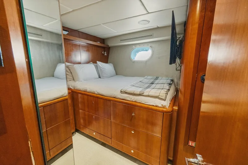  Yacht Photos Pics Luxurious cabin interior of 1999 Trinity Yachts Raised Pilothouse with wooden furnishings and porthole.