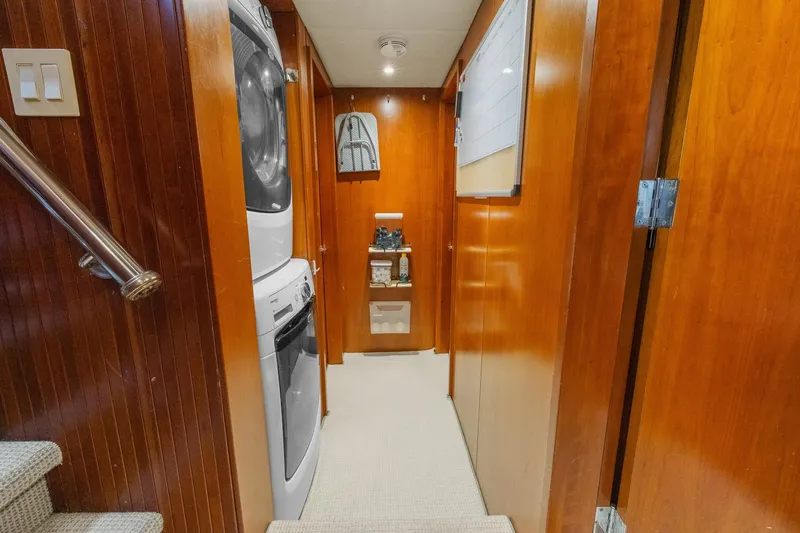  Yacht Photos Pics Laundry area in 1999 Trinity Yachts Raised Pilothouse with wood paneling and stacked washer-dryer.
