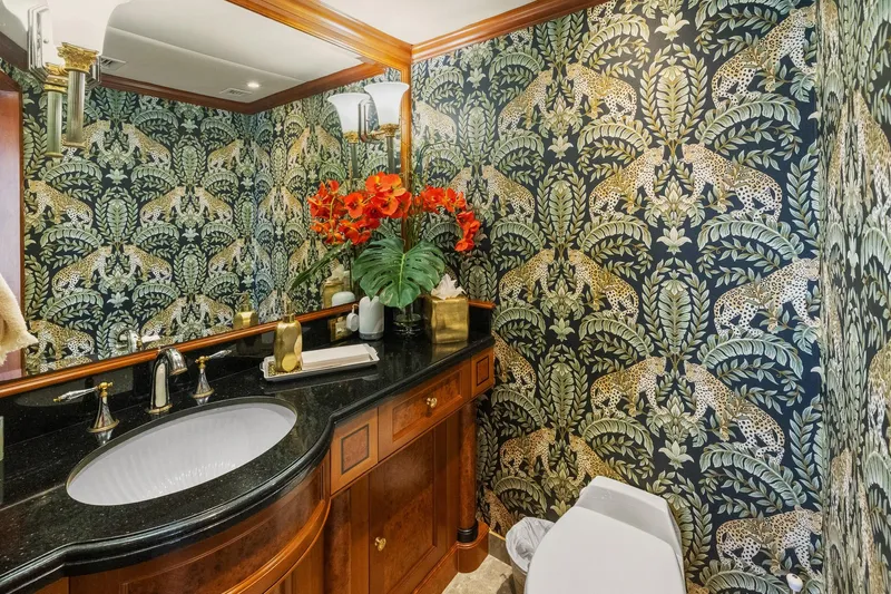 Yacht Photos Pics Luxurious yacht bathroom with leopard-themed wallpaper, elegant fixtures, and vibrant floral arrangement.