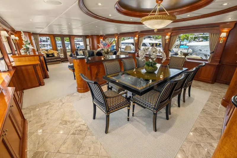  Yacht Photos Pics Luxurious interior of 1999 Trinity Yachts Raised Pilothouse, featuring elegant dining area and decor.