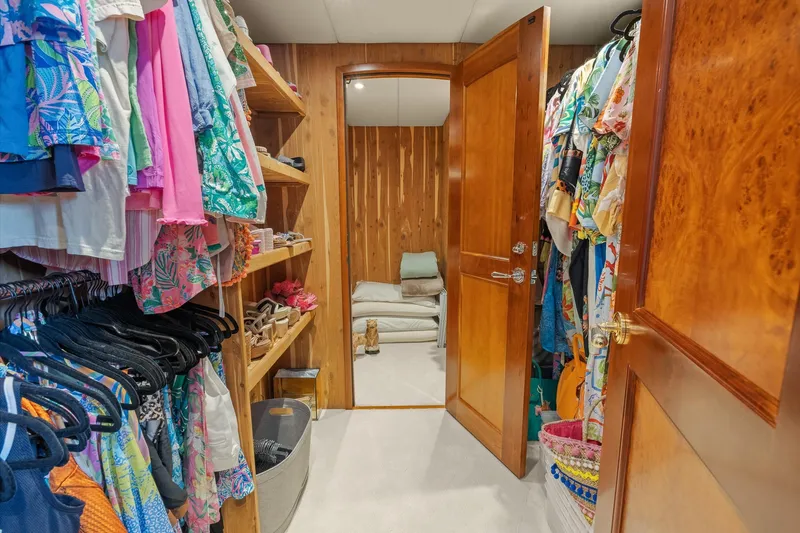  Yacht Photos Pics Luxurious yacht closet with colorful clothing and wooden shelves, Trinity Yachts Raised Pilothouse 1999.