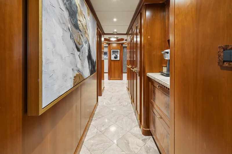  Yacht Photos Pics Luxurious hallway in 1999 Trinity Yachts Raised Pilothouse, featuring elegant wood paneling and artwork.