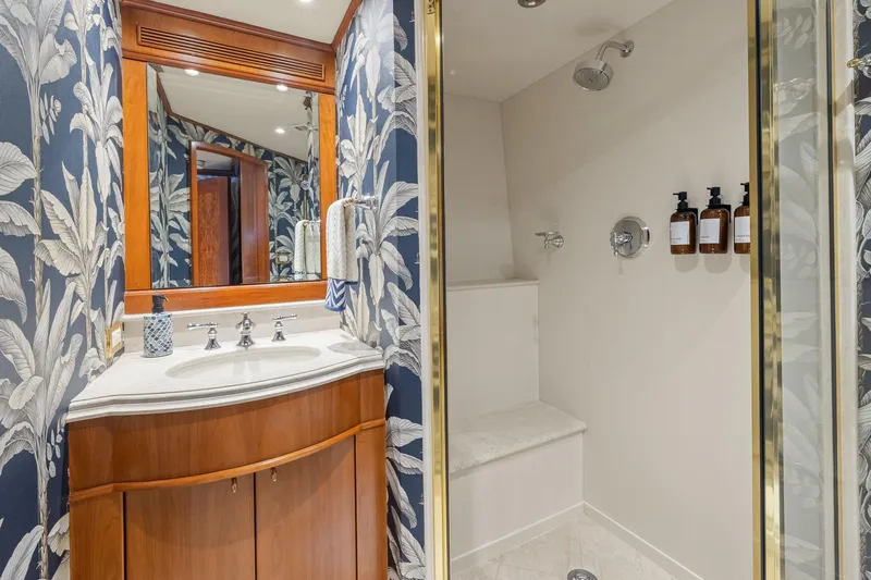  Yacht Photos Pics Luxurious bathroom on 1999 Trinity Yachts Raised Pilothouse, featuring elegant floral wallpaper and modern fixtures.
