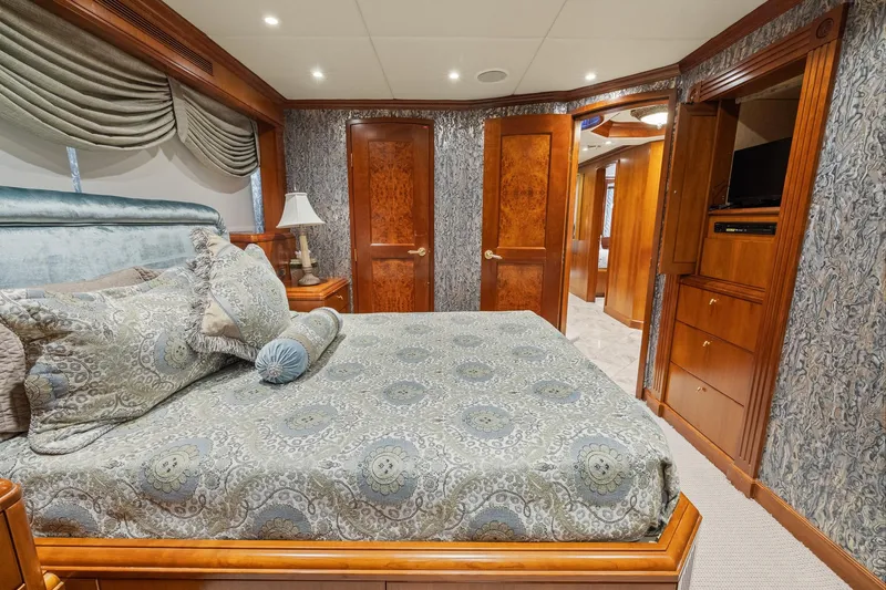  Yacht Photos Pics Luxurious bedroom interior on 1999 Trinity Yachts Raised Pilothouse, featuring elegant wood finishes and plush bedding.