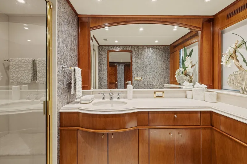  Yacht Photos Pics Luxurious bathroom on 1999 Trinity Yachts Raised Pilothouse, featuring elegant wood cabinetry and marble accents.