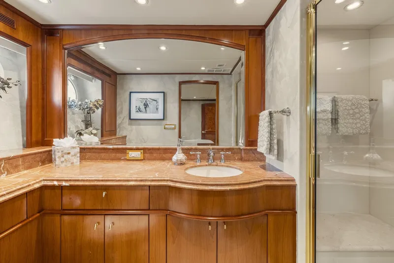  Yacht Photos Pics Luxurious yacht bathroom with wooden cabinetry, marble countertop, and glass shower, Trinity Yachts 1999 model.