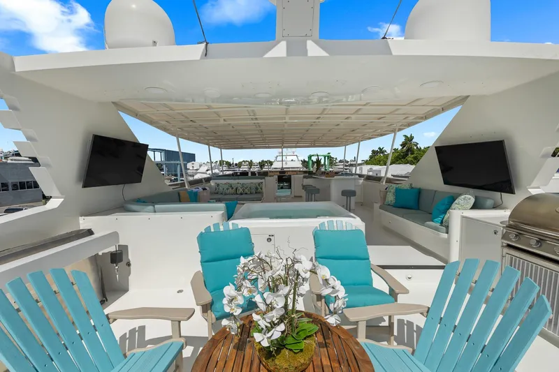  Yacht Photos Pics Luxurious 1999 Trinity Yachts Raised Pilothouse with outdoor seating, TVs, and a grill.