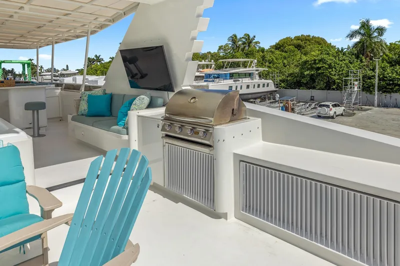  Yacht Photos Pics Luxurious 1999 Trinity Yachts Raised Pilothouse deck with seating, grill, and TV.