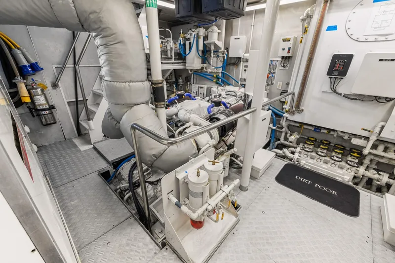  Yacht Photos Pics Engine room of a 1999 Trinity Yachts Raised Pilothouse, showcasing machinery and piping.