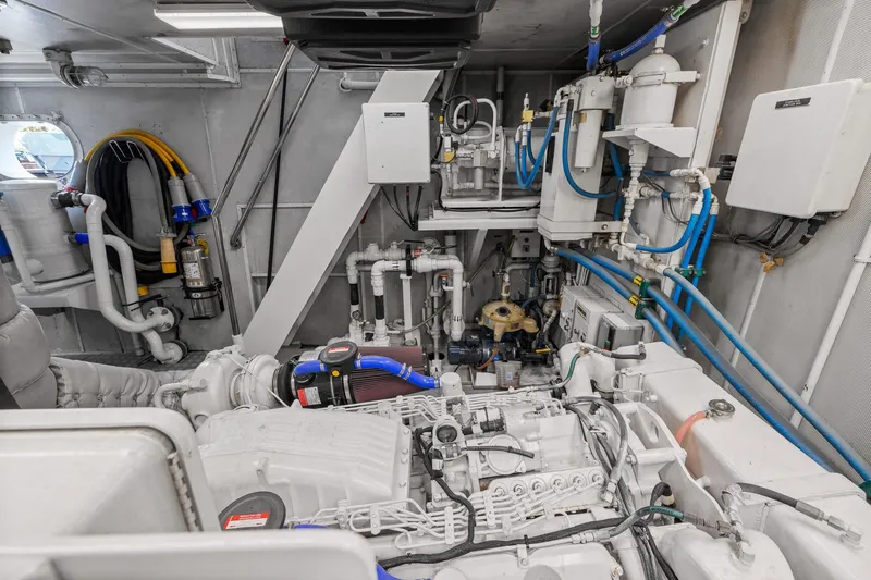  Yacht Photos Pics Engine room of 1999 Trinity Yachts Raised Pilothouse, showcasing complex machinery and piping.