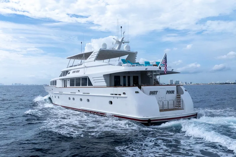  Yacht Photos Pics Luxurious 1999 Trinity Yachts Raised Pilothouse cruising on open sea under a cloudy sky.