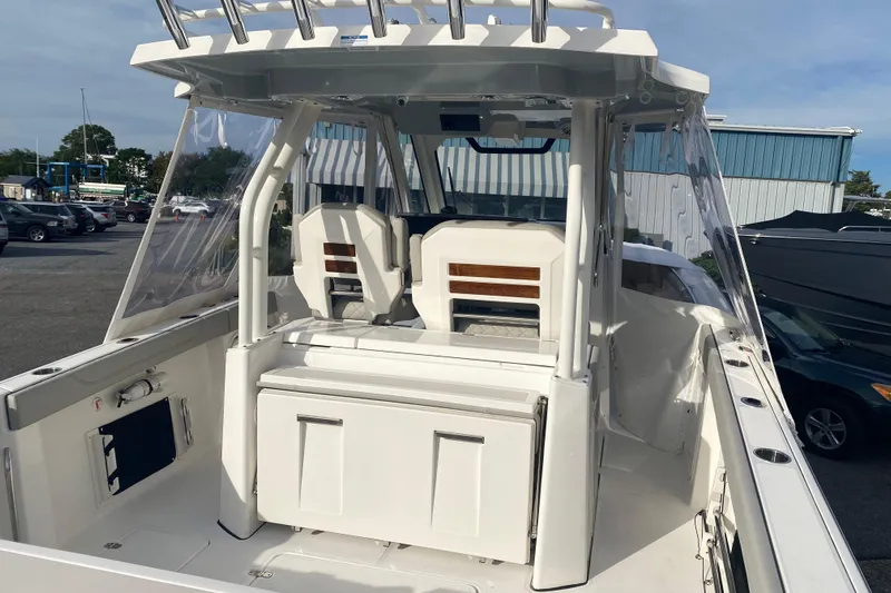  Yacht Photos Pics 2024 Pursuit S 328 Sport boat interior with seating and storage, docked outdoors.