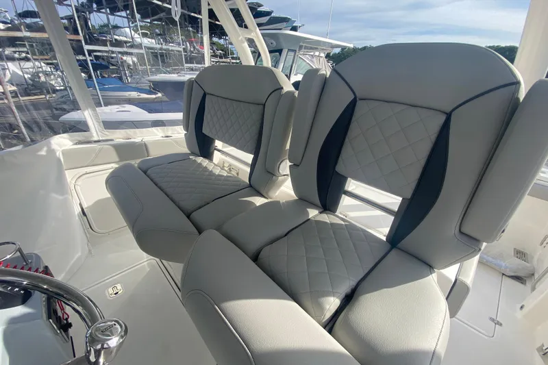  Yacht Photos Pics 2024 Pursuit S 328 Sport boat seats with quilted design, docked in marina.
