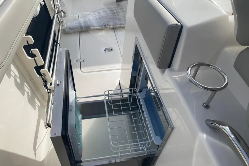 Yacht Photos Pics 2024 Pursuit S 328 Sport boat interior with open storage compartment and cup holder.