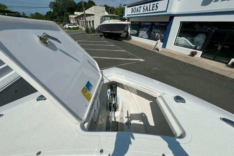  Yacht Photos Pics 2024 Pursuit S 328 Sport boat at dealership with open storage compartment.