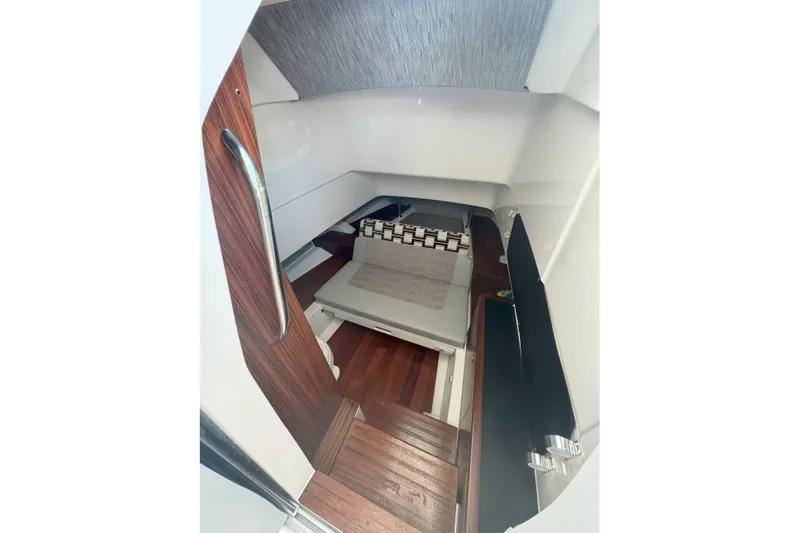  Yacht Photos Pics 2024 Pursuit S 328 Sport cabin interior with wooden flooring and seating area.