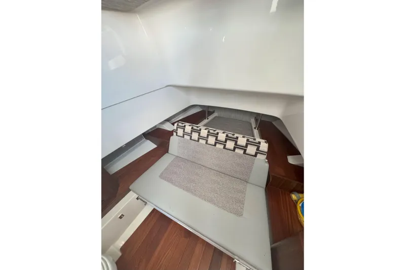  Yacht Photos Pics 2024 Pursuit S 328 Sport cabin interior with modern seating and wooden flooring.