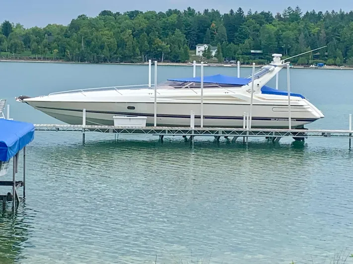 Tude Yacht Photos Pics 1995 Sunseeker Apache 45 boat docked on a lake with forested shoreline.